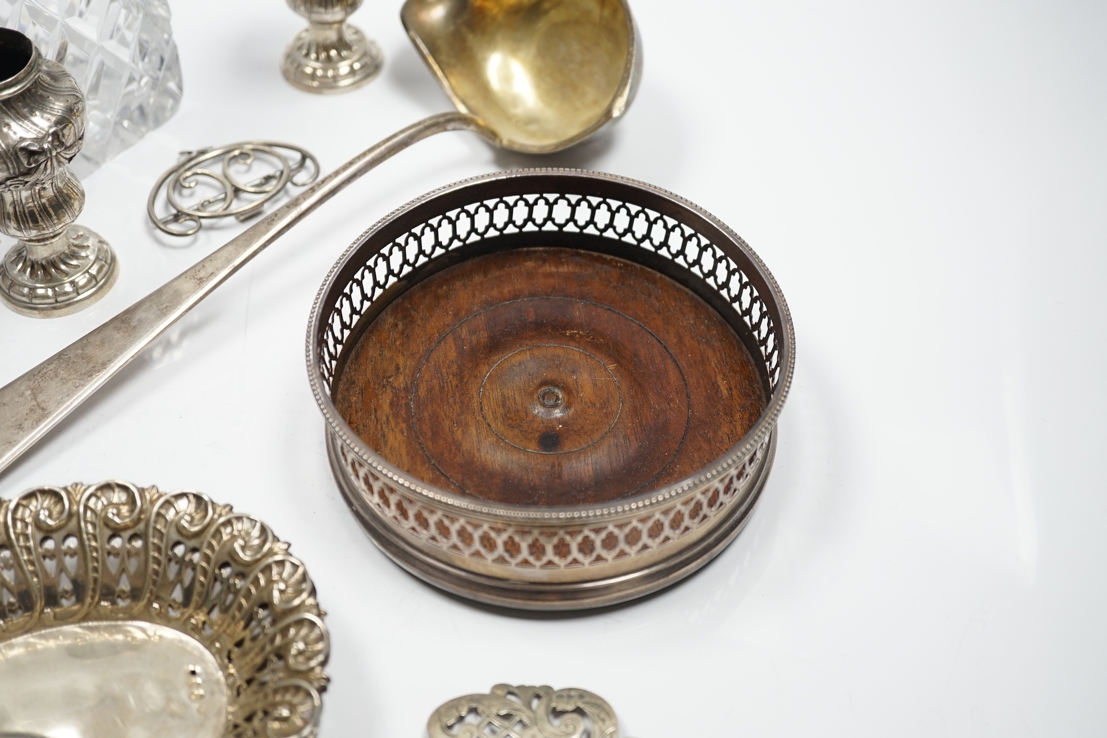 Assorted silver and white metal items including a pair of late Victorian pierced silver bonbon dishes, a pierced silver small bowl, a modern silver wine coaster, a silver belt buckle, white metal belt buckle, two contine